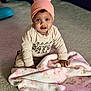 Xaya is registered to the contest to win money with this photo: baby, infant, child, beanie, hat, blanket, floral_blanket, carpet, indoor, sitting, portrait, cute, eyes, face, hands, clothing, pink, cozy, smile, playful