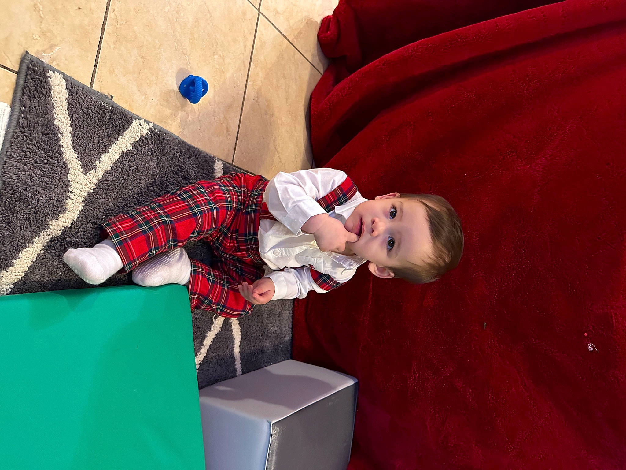 Julian is registered to the contest to win money with this photo: baby, baby_toddler_clothing, carmine, child, comfort, flooring, linens, magenta, pattern, person, plaid, play, room, shipping_box, sitting, sleeve, sock, tartan, textile, toddler