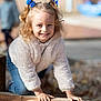 child, girl, smile, blue_bows, curly_hair, outdoor, wooden_beam, playful, happy, casual_clothing, white_jacket, jeans, daylight, fun, childhood, portrait, young, cute, hands, nature