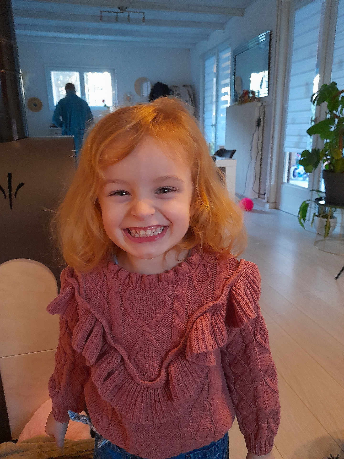 Mélodie participe au concours pour gagner de l'argent avec cette photo : child, girl, smile, red_hair, sweater, knitwear, indoor, home, happy, person, young_child, candid, portrait, casual, furniture, plant, background, light, warm, cozy