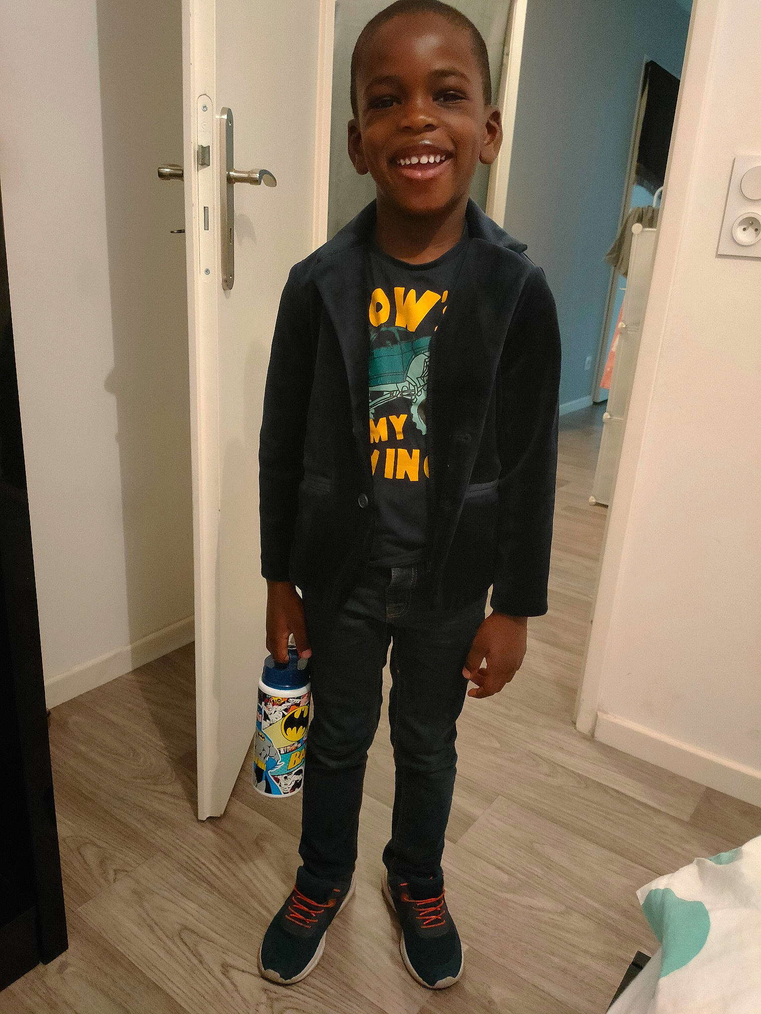 Basit participe au concours pour gagner de l'argent avec cette photo : child, door, electric_blue, face, floor, flooring, gas, hairstyle, happy, hardwood, head, joy, knee, person, sleeve, smile, sportswear, standing, sweatpant, t_shirt