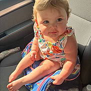 Annabelle is registered to the contest to win money with this photo: baby, backpack, car_interior, car_seat, child, clothing, colorful, curly_hair, cute, drool, expression, face, feet, hand, infant, legs, person, seat, skin, sunlight