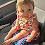 baby, child, car_seat, backpack, sunlight, curly_hair, drool, clothing, colorful, seat, car_interior, person, skin, legs, feet, hand, face, expression, cute, infant