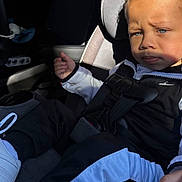 Rylee Rice is registered to the contest to win money with this photo: toddler, child, car_seat, curly_hair, blue_eyes, sportswear, seatbelt, car_interior, sunlight, shadow, serious_expression, clothing, footwear, young_child, portrait, baby, person, indoor, transportation, sitting