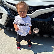 Rylee Rice joined the competition — help win amazing prizes! toddler, child, curly_hair, white_tshirt, nike_air, black_shorts, sneakers, red_and_black_shoes, car, white_car, toyota_logo, outdoor, concrete, shadow, daylight, standing, person, cute, sunlight, portrait