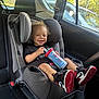 Rylee Rice joined the competition — help win amazing prizes! toddler, child, car_seat, car_interior, smiling, sippy_cup, spiderman, shoe, sneaker, seatbelt, window, sunlight, curly_hair, happy, black_tshirt, car, seat, roadside, greenery, person