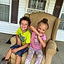 Kinslee is registered to the contest to win money with this photo: children, boy, girl, armchair, porch, smiling, happy, casual_clothing, boots, window, door, home, outdoor, patterned_fabric, curly_hair, bun_hair, concrete_floor, playful_pose, siblings, daylight