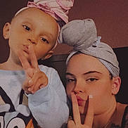 Kinslee joined the competition — help win amazing prizes! child, adult, headwrap, peace_sign, pout, indoor, portrait, person, hand_gesture, casual_clothing, tattoo, long_nails, smile, family, togetherness, fun, fashion, cozy, closeup, warm_lighting