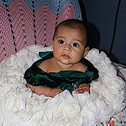 Ailani is registered to the contest to win money with this photo: animal_print, baby, child, colorful_pillow, curious, cute, decor, fabric, face, foot, green_dress, head, indoor, infant, person, portrait, sitting, soft_texture, white_cushion, young_child