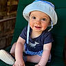 baby, child, smiling, hat, blue_shirt, striped_shorts, cushion, green_chair, cute, happy, indoor, portrait, infant, hands, feet, clothing, face, person, sitting, sun_hat