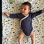 arm, baby, blanket, child, clouds, comfort, cute, fabric, face, head, indoors, infant, leg, lying_down, newborn, onesie, pacifier, pattern, sleepwear, stars