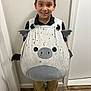 Andrew joined the competition — help win amazing prizes! black_shirt, black_shoes, brown_pants, casual, child, costume, cute, door, fantasy, happy, horns, indoors, person, playful, portrait, smiling, standing, white_wall, wings, wood_floor