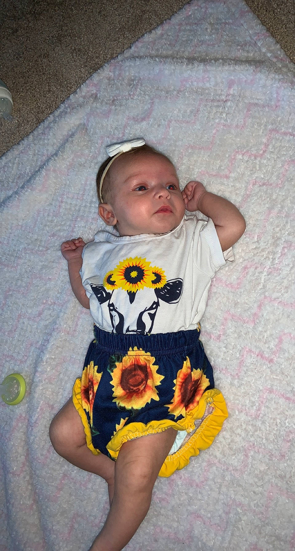 Hazel is registered to the contest to win money with this photo: baby, baby_products, baby_toddler_clothing, chair, child, comfort, face, flower, happy, human_leg, iris, linens, orange, pattern, person, plant, sitting, sleeve, t_shirt, thigh