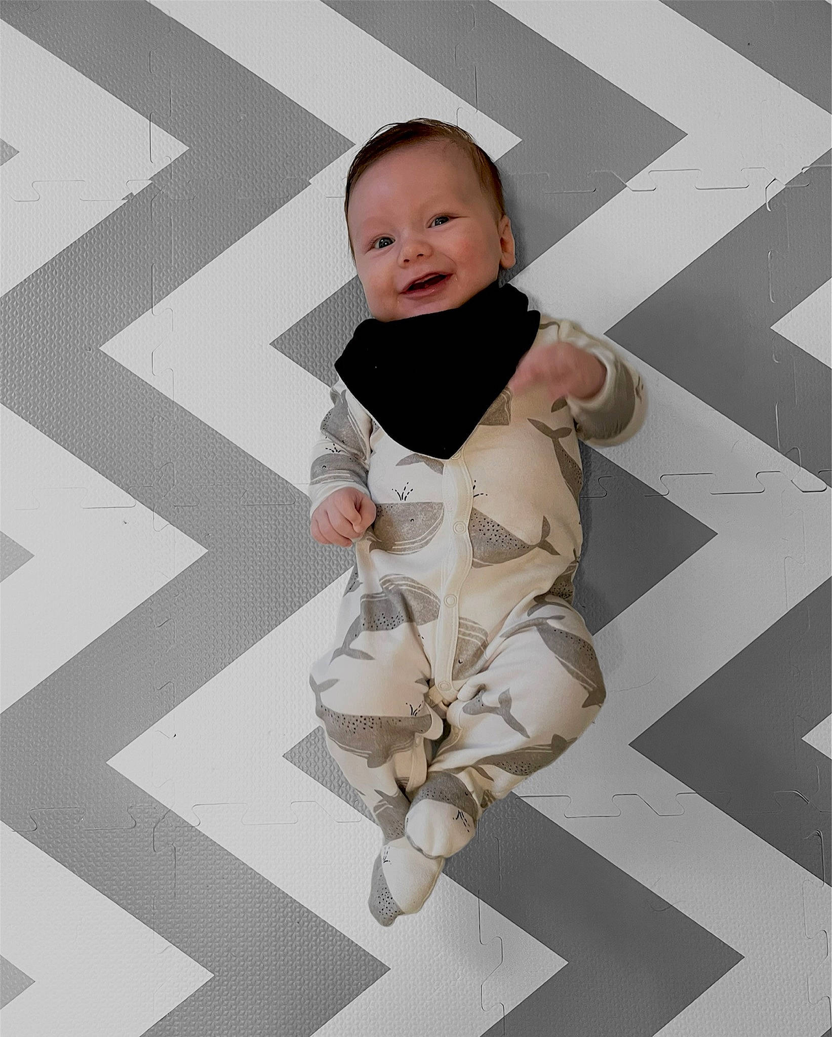 Kohen is registered to the contest to win money with this photo: baby, baby_toddler_clothing, black_and_white, child, fashion_design, flooring, font, gesture, hairstyle, happy, human_leg, monochrome, monochrome_photography, pattern, person, product, sleeve, standing, style, thigh