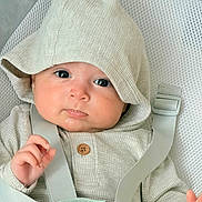 Axel is registered to the contest to win money with this photo: baby, baby_seat, beige, bright_eyes, button, child, closeup, comfortable, cute, hand, hooded_clothing, indoor, infant, mesh_seat, portrait, pout, sitting, soft_light, straps, warm_clothing