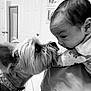 black_and_white, baby, dog, face, indoor, interaction, pet, child, curious, close_up, portrait, animal, person, cute, candid, room, door, photo_frame, love, affection