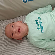 Ayden a rejoint le concours — aidez-le/la à gagner de superbes lots ! baby, blanket, child, clothing, cozy, cute, face, happy, indoors, infant, joyful, lying_down, mint_green, person, portrait, sleeping_area, smiling, striped, text_on_clothing, young