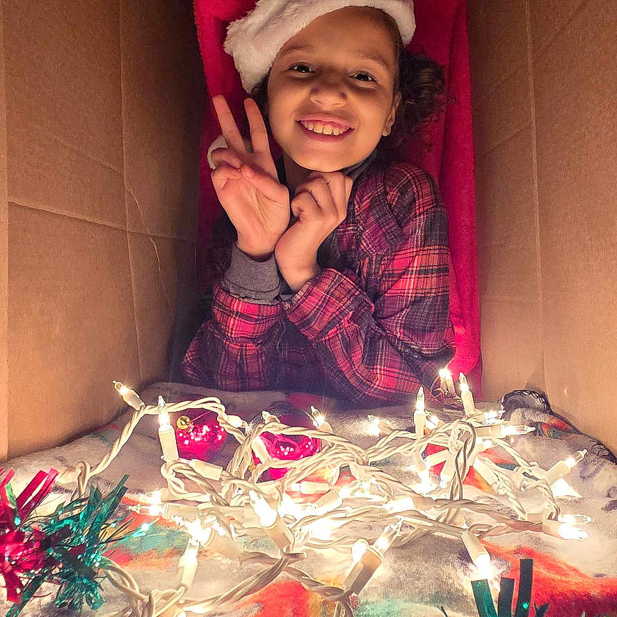 Anaya joined the competition — help win amazing prizes! accessories, baby, box, candle, cap, clothing, coat, face, glasses, happy, hat, head, indoors, jacket, laughing, lighting, person, photography, portrait, smile