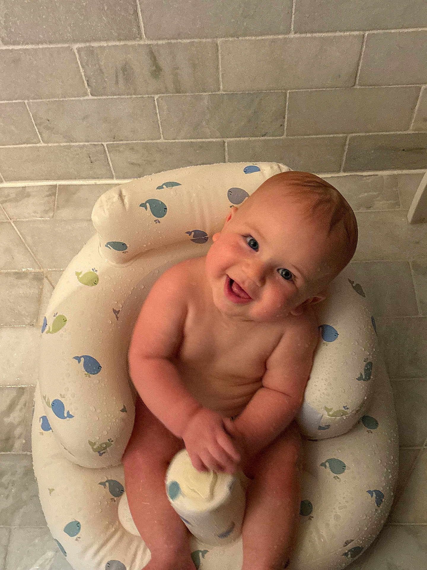 Roan joined the competition — help win amazing prizes! baby, child, infant, smiling, sitting, bathroom, inflatable_seat, whale_pattern, bottle, wet, tile_floor, cute, happy, naked, skin, water_drops, playful, indoors, person, young