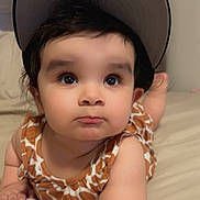 Sonia joined the competition — help win amazing prizes! arm, baby, bed, bedding, cap, child, clothing, curious, cute, expression, eyes, face, giraffe_print, hat, indoors, infant, lying_down, person, portrait, skin
