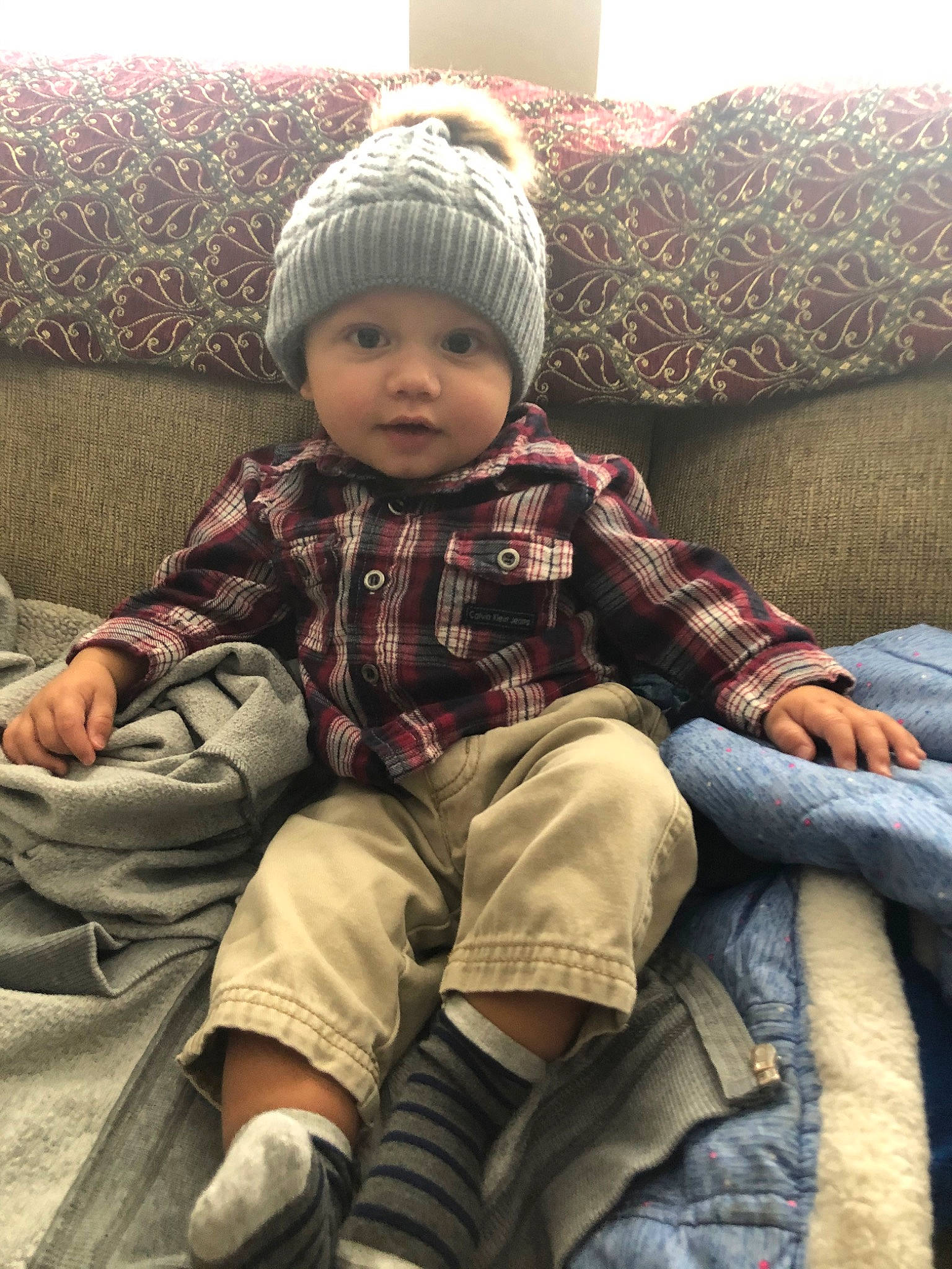 Radley is registered to the contest to win money with this photo: baby, beanie, cheek, child, headgear, headwear, knit_cap, person, sitting, skin, smile, toddler