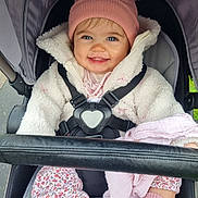 Ettie joined the competition — help win amazing prizes! baby, child, smiling, stroller, hat, pink, jacket, coat, blue_eyes, happy, cute, outdoor, clothing, seatbelt, blanket, sock, person, infant, portrait, warm_clothes