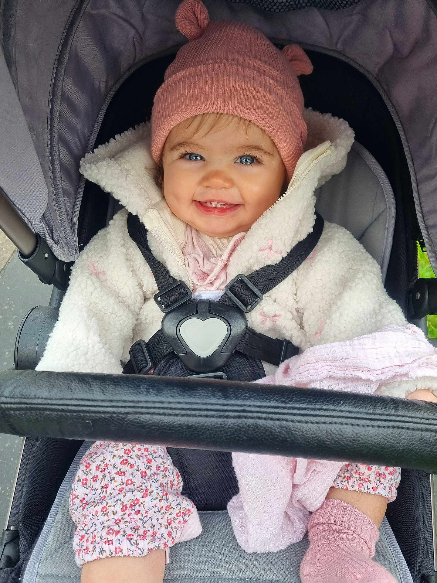 Ettie joined the competition — help win amazing prizes! baby, child, smiling, stroller, hat, pink, jacket, coat, blue_eyes, happy, cute, outdoor, clothing, seatbelt, blanket, sock, person, infant, portrait, warm_clothes