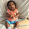 Kashton is registered to the contest to win money with this photo: baby, child, infant, couch, clothing, socks, hands, face, curious, indoor, seated, textile, portrait, cute, casual, comfortable, young, expression, skin, sitting