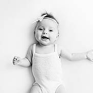 Ava participe au concours pour gagner de l'argent avec cette photo : arms_outstretched, baby, black_and_white, child, clothing, cute, face, happy, headband, human, infant, innocent, isolated, one_person, portrait, smile, soft_lighting, studio, white_background, young