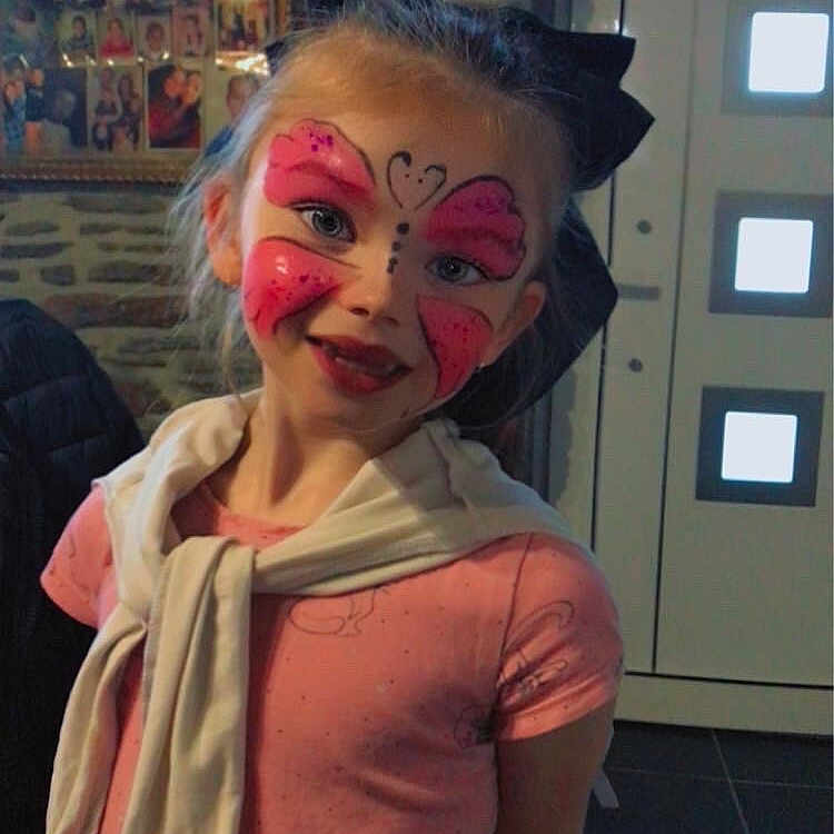 Zelda a rejoint le concours — aidez-le/la à gagner de superbes lots ! bow, butterfly, casual_clothing, child, door, dress, face_paint, girl, happy, headband, indoor, photography, pink, portrait, smile, standing, stone_wall, tile_floor, white_sweater, young