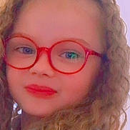 Zelda participe au concours pour gagner de l'argent avec cette photo : child, curly_hair, glasses, red_glasses, face, portrait, close_up, selfie, smile, lipstick, long_hair, hair, eyewear, indoor, pastel_background, young_person, filtered_photo, fashionable, warm_tones, headshot