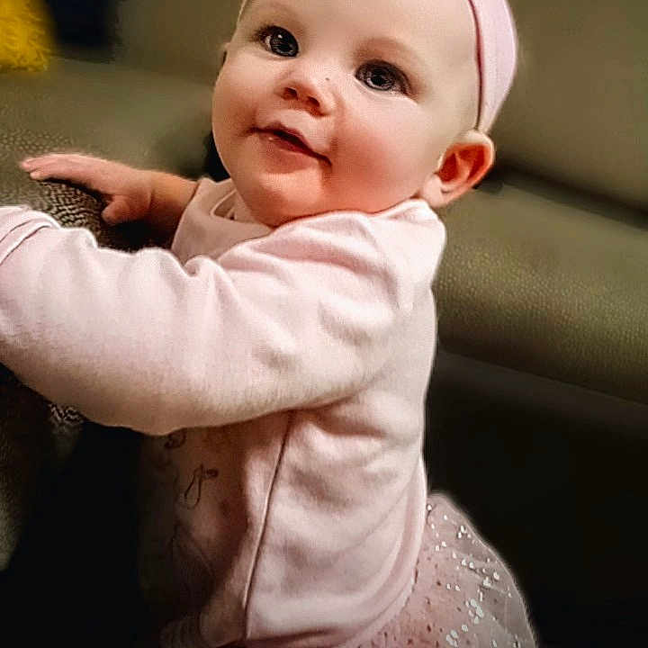 Arielle is registered to the contest to win money with this photo: baby, child, cozy, cute, eyes, face, furniture, girl, hand, happy, headband, indoor, infant, pink_clothing, portrait, smile, soft_light, sparkle, tutu, young_child