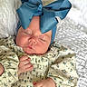 Meilani is registered to the contest to win money with this photo: adorable, baby, blanket, blue_bow, child, closeup, cozy, cute, floral_dress, hands, headband, indoors, infant, newborn, peaceful, portrait, resting, skin, sleeping, soft_texture