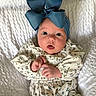 adorable, baby, baby_clothing, blue_bow, child, closeup, comfortable, cozy, curious_eyes, cute, fashion, floral_dress, headband, indoors, infant, portrait, sitting, small_hands, soft_lighting, white_blanket