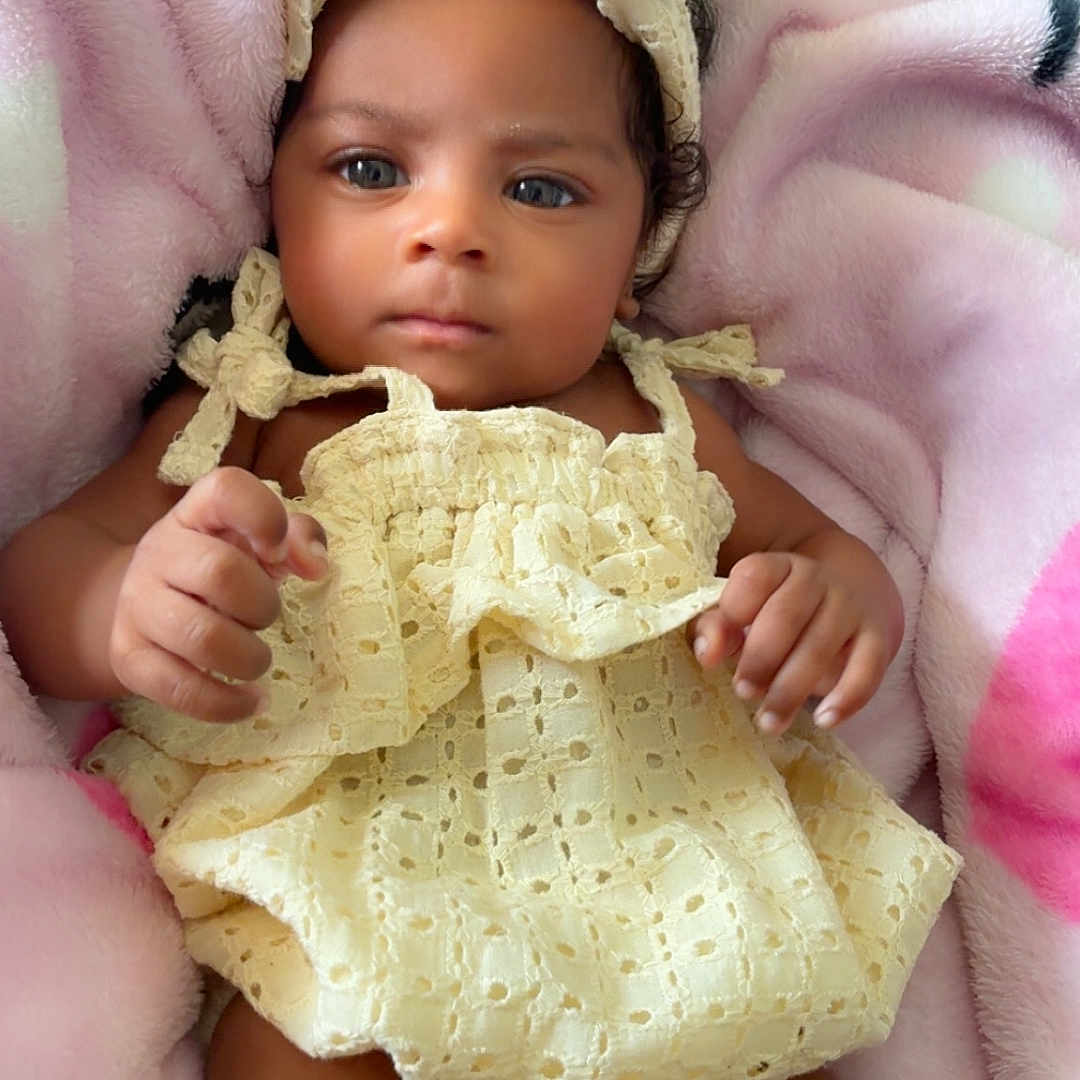 Legaci Velazquez is registered to the contest to win money with this photo: baby, infant, child, yellow_dress, headband, blanket, soft_texture, cute, portrait, indoors, lying_down, skin, hand, legs, curious, comfortable, cozy, closeup, person, newborn