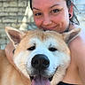 affection, animal, canine, closeup, dog, earrings, face, friendly, fur, happy, hugging, human, outdoor, person, pet, piercing, portrait, smile, stone_wall, tongue_out