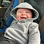 baby, hoodie, smile, car_seat, blue, black, clothing, child, happy, infant, portrait, seatbelt, cute, casual, sitting, young, face, cozy, warm, indoor