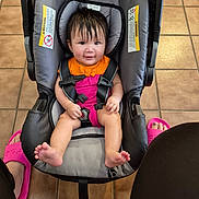 Hasdasa joined the competition — help win amazing prizes! baby, child, infant, smiling, car_seat, safety_harness, buckled, pink_clothing, orange_clothing, bare_feet, indoor, tile_floor, portrait, seated, happy, dark_hair, face, photography, adult_sandals, household