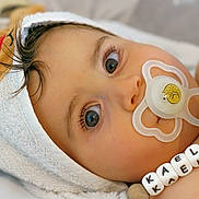 Kaël a rejoint le concours — aidez-le/la à gagner de superbes lots ! baby, pacifier, towel, reindeer_hood, beads, close_up, child, infant, blanket, blue_object, cute, eyes, face, hand, indoors, soft_lighting, portrait, skin, young, person