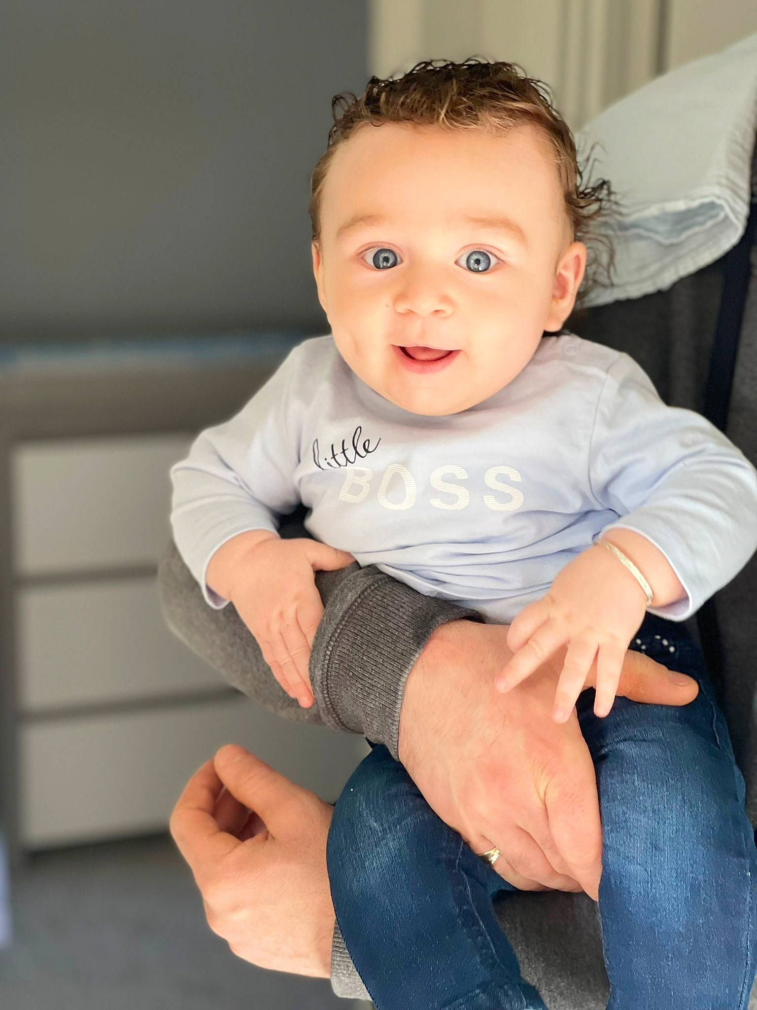 Ernie is registered to the contest to win money with this photo: arm, baby_toddler_clothing, cheek, comfort, eye, face, finger, flash_photography, hair, hand, head, human_body, iris, joint, leg, neck, person, skin, sleeve, smile