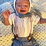 Jaxon is registered to the contest to win money with this photo: baby, smiling, white_hat, bow_tie, suspenders, blue_pants, crocheted_blanket, lying_down, happy, infant, cute, portrait, clothing, hand, face, child, indoor, soft_texture, cozy, person