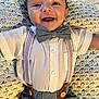 baby, smiling, bow_tie, suspenders, white_shirt, blue_pants, crocheted_blanket, happy, infant, portrait, cute, lying_down, closeup, child, fashion, buttoned_shirt, indoors, person, young_child, cheerful