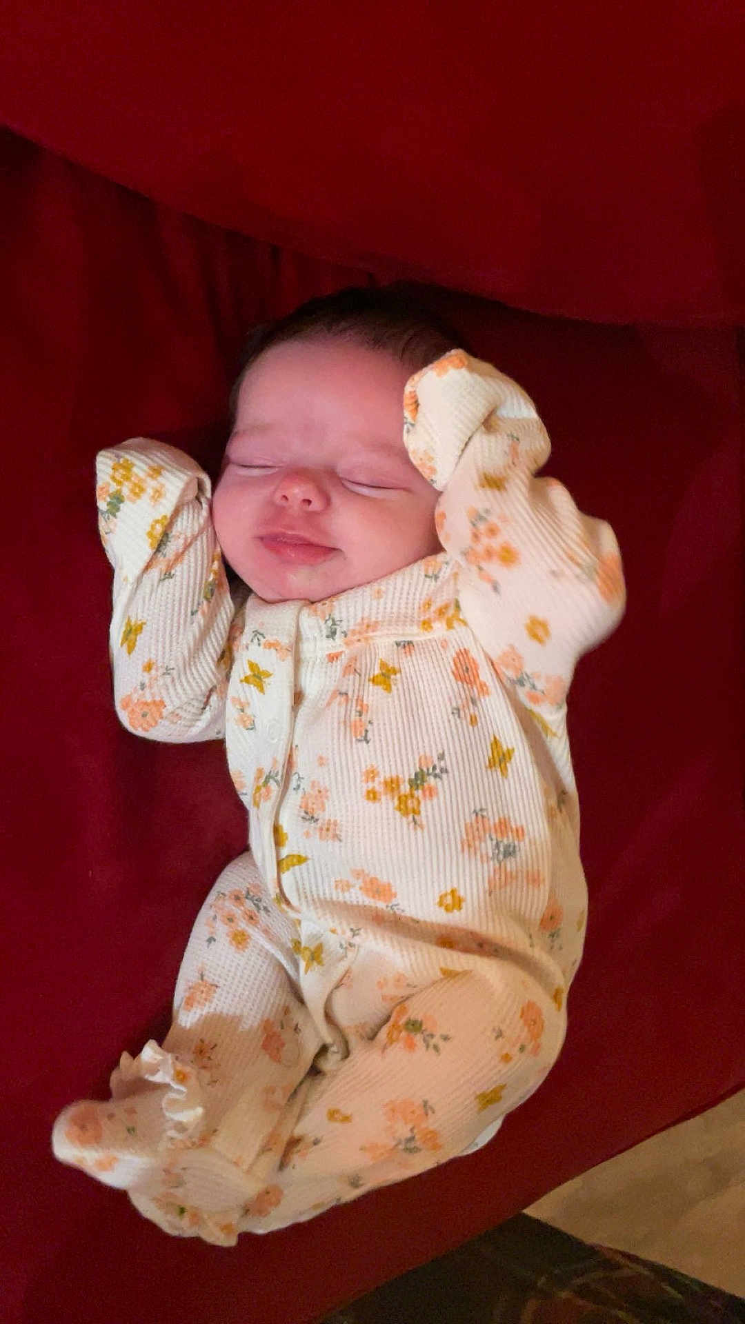 Emery joined the competition — help win amazing prizes! baby, sleeping, infant, onesie, floral_pattern, blanket, red_background, cute, peaceful, child, newborn, soft, cozy, hands_up, comfortable, resting, portrait, indoors, small, adorable