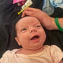 Emery is registered to the contest to win money with this photo: baby, smiling, hand, bottle, wipes, infant, clothing, person, closeup, face, happy, lying_down, bed, care, newborn, skin, head, expression, child, domestic