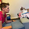 Lemon joined the competition — help win amazing prizes! person, cat, yoga_mat, kettlebell, exercise_equipment, indoor, relaxation, meditation, pet, animal, blanket, resting, calm, short_hair, pink_shirt, floor, wall, home, quiet, focus
