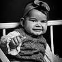 Soline a rejoint le concours — aidez-le/la à gagner de superbes lots ! baby, child, smile, headband, bow, knitwear, sweater, jeans, hand, chair, portrait, black_and_white, cute, infant, seated, cozy, happy, young_child, studio, expression