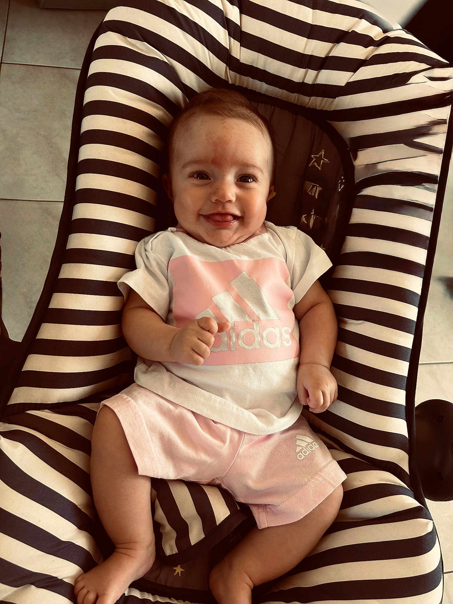 Celeste a rejoint le concours — aidez-le/la à gagner de superbes lots ! baby, child, smiling, adidas, clothing, striped, cushion, seat, indoor, floor, happy, person, infant, shorts, tshirt, foot, hand, cute, portrait, relaxed