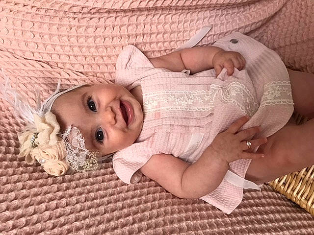 Mérite participe au concours pour gagner de l'argent avec cette photo : baby, baby_toddler_clothing, cheek, child, comfort, dress, eyelash, flooring, happy, head, headwear, iris, joy, linens, lip, mouth, nose, pattern, person, skin