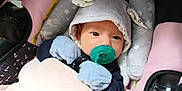 Alice is registered to the contest to win money with this photo: baby, pacifier, mittens, hood, car_seat, blanket, infant, cute, child, face, person, clothing, soft, resting, comfort, indoors, newborn, pink, gray, blue