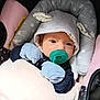 baby, pacifier, mittens, hood, car_seat, blanket, infant, cute, child, face, person, clothing, soft, resting, comfort, indoors, newborn, pink, gray, blue